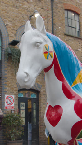 Vídeo-Vertical-De-Una-Escultura-Pintada-De-Un-Caballo-En-Las-Afueras-De-Camden-Lock-Market-Hall-En-El-Norte-De-Londres,-Reino-Unido